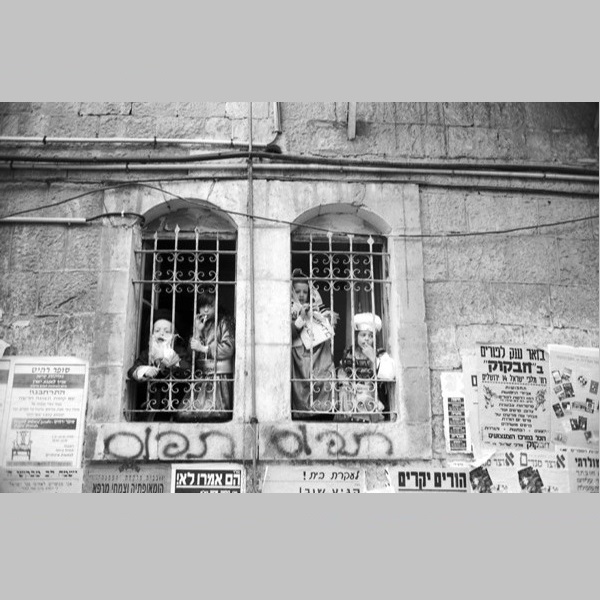 Children looking out from barred window portals